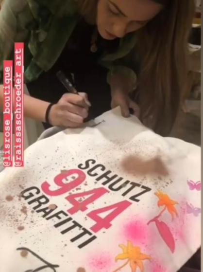 Artista pintando bolsa durante ativação de marca